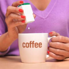 Eine Frau macht Süßstoff in ihren Kaffee