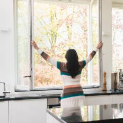 Lüften: Eine Frau öffnet das Küchenfenster