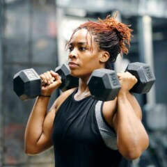 Wie Frauen ihre Muskeln richtig trainieren: Frau beim Hanteltraining