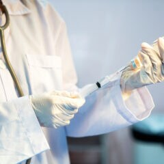 Mediziner zieht Impfstoff in eine Spritze