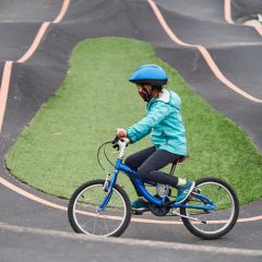Ein Kind fährt mit einem Fahrrad auf dem Pumptrack