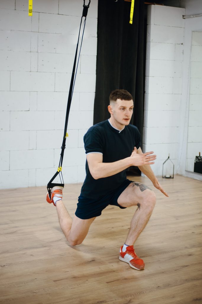 Man doing sprinter lunges with TRX strap