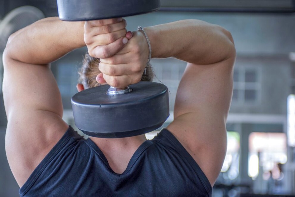 The triceps-overhead exercise can be performed not only on the cable train, but also with a dumbbell that you hold behind your neck and push up.
